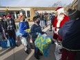 Students at St. Andre Catholic Elementary Schoo fill a school bus with toys and food they've collected for those in need, on Friday, Dec. 10, 2021.  The collected items will be heading to the Children's Aid Society and the Sandwich Teen Action Group.