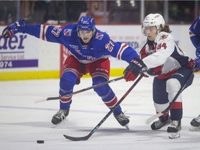 Kitchener's Roman Schmidt and Windsor's Oliver Peer battle for the puck during the first period of OHL action between the Kitchener Rangers and the Windsor Spitfires at the WFCU Centre, on Saturday, Dec. 11, 2021.