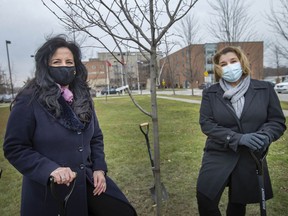 Alina Sirbu, left, Huron Lodge Executive Director, and Jelena Payne, Commissioner of Human and Health Services at the City of Windsor, stand next to a newly planted tree on the grounds of Huron Lodge to commemorate the toll COVID-19 has taken on long-term care homes and vulnerable residents, on Thursday, Dec. 9, 2021.