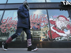 A pedestrian walks by a holiday season mural in downtown Windsor on Dec. 22, 2021.