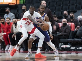 Raptors forward Chris Boucher (25) controls the ball as Phoenix Suns guard Chris Paul (3) defends during the fourth quarter at Scotiabank Arena on Tuesday.