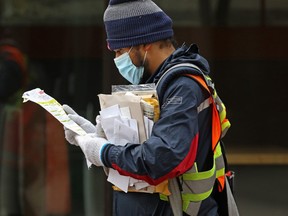 A Canada Post mail carrier delivers mail to business along Stephen Avenue Mall during the lunch hour.
