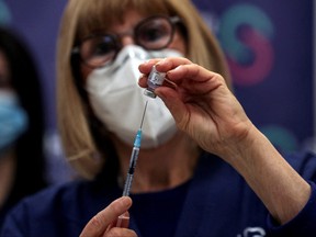 A nurse prepares a fourth dose of a COVID-19 vaccine as part of a trial in Israel, at Sheba Medical Center in Ramat Gan, Israel, Dec. 27, 2021.