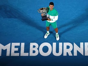 In this file photo taken on February 21, 2021, Novak Djokovic holds the Norman Brookes Challenge Cup after winning the Australian Open in Melbourne.