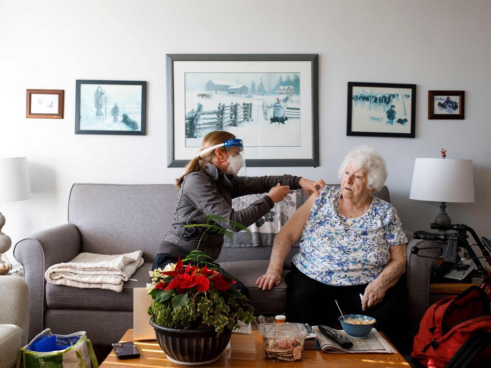 Dr. Christa Sinclair-Mills of House Calls, a mobile healthcare unit for homebound seniors, visits with Geraldine Anderson to administer her Covid-19 booster shot in her Toronto apartment in Toronto, Ontario, Canada, on January 21, 2022.