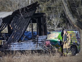 An assistant deputy chief of the Amherstburg Fire Department and an officer with Windsor Police inspect a barn fire on Concession Road 6 North, that killed several exotic animals, on Friday, January 21, 2022.