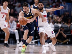 Denver Nuggets guard Facundo Campazzo and Detroit Pistons guard Cassius Stanley battle for the ball in the fourth quarter at Ball Arena.