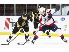 Windsor Spitfires' defenceman Andrew Perrott, right, sends a pass away from Sarnia Sting's Max Namestnikov in the first period at Progressive Auto Sales Arena in Sarnia on Friday.