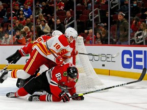 Chicago Blackhawks defenceman Caleb Jones (82) falls while defending against Calgary Flames centre Tyler Pitlick (18) during the third period at United Center in Chicago, Jan. 2, 2022.