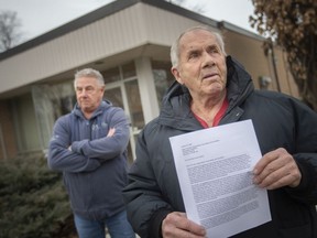 Lifelong Stoney Point residents, Paul Crack and Wayne Zimney, left, stand outside the former Stoney Point library branch, with Crack holding a cover letter for the petition they submitted to have the library reopened, on Wednesday, Jan. 12, 2022.