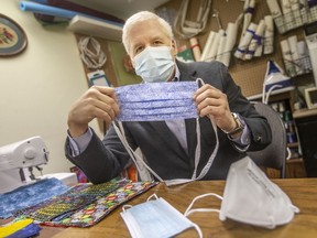 Ken Drouillard, professor at the Great Lakes Institute for Environmental Research, and who participated in a mask study to see what approach is comparable to an N95 mask, is pictured at his home on Monday, January 17, 2022.  Here he holds a cloth mask that when tied tight over a surgical mask can be comparable to an N95 mask.