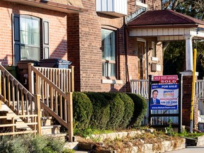 A for sale sign is displayed outside a home in Toronto.