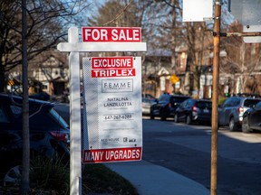 A for sale sign is displayed outside a home in Toronto on Dec. 13, 2021.