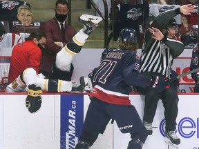 The Sarnia Sting's Chandler Romeo of the Sarnia is dumped into the Windsor bench by Spitfires' forward Josh Currie during Thursday's game.