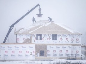 Roofers brave snowy conditions to work on a new home near Lauzon Road in Windsor on Jan. 24, 2022.