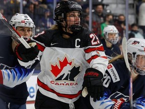 Team Canada captain Marie-Philip Poulin skates between Team U.S.A. Jincy Dunne and Hannah Brandt during their international hockey exhibition game on a My Why Tour stop in Maryland Heights, Missouri, U.S. December 17, 2021.
