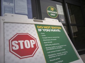 A COVID-19 screening sign is seen at the entrance to the south campus of St. Clair College, on Tuesday, January 18, 2022.