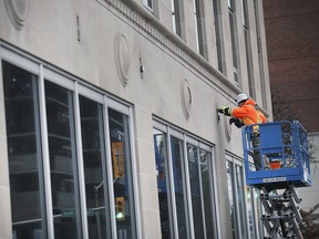 Des techniciens travaillent sur la façade de l'ancien édifice Enwin Utilities sur Ouellette le jeudi 9 décembre 2021, qui abrite maintenant Tessonic Inc.