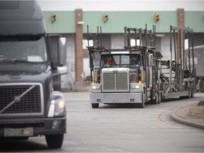 Transport trucks enter Canada after being cleared by Canada Border Services Agency at the Ambassador Bridge on Friday, Jan. 14, 2022. As of Saturday, unvaccinated truckers can't cross the Canada-U.S.A. border.