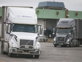 Transport trucks enter Canada after being cleared by the Canada Border Services Agency at the Ambassador Bridge on Friday.