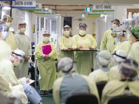 In this May 13, 2020, file photo, front-line medical staff hold a meeting at the Windsor Regional Hospital Field Hospital at the St. Clair College SportsPlex, early in the COVID-19 pandemic.