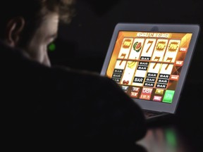 In this photo illustration a man gambles on his computer on an online slot machine.