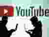 Silhouettes of mobile device users are seen next to a screen projection of a YouTube logo in this picture illustration taken March 28, 2018.