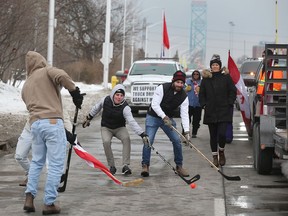 Anti-mandate protestors play road hockey in a lane of Huron Church Road southbound on Monday, Feb. 7, 2022.