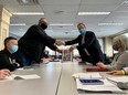 Unifor Local 444 president David Cassidy (left) and Caesars Windsor president Kevin Laforet (right) shake hands at the bargaining table on Feb. 18, 2022.