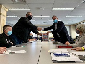 Unifor Local 444 president David Cassidy (left) and Caesars Windsor president Kevin Laforet (right) shake hands at the bargaining table on Feb. 18, 2022.