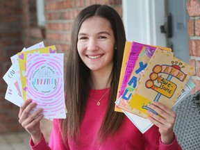 Emily Truman poses with letters destined for local senior citizens at her Lakeshore home on Wednesday, February 16, 2022.