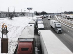 Trucks wait on Interstate 75 for the re-opening of Ambassador Bridge in Detroit, Michigan, on Feb. 8, 2022.