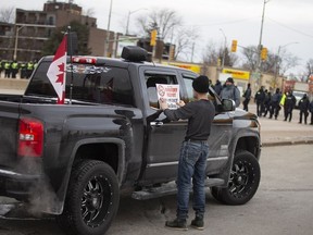 Protesters voluntarily leave the intersection of College Avenue and Huron Church Road, an intersection they have been holding for several days, as a large police force marched south on Huron Church Road, on Sunday, February 13, 2022.