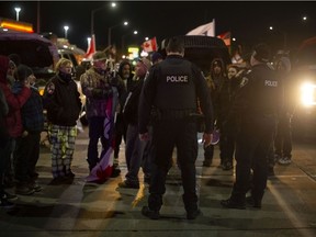 Officers with the Windsor Police Service speak with protesters Wednesday night, Feb. 9, 2022, after they occupied three north-bound lanes south of Tecumseh Road West, outside of the police perimeter.