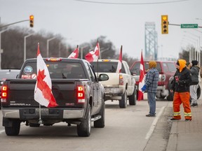 Protesters voluntarily leave the intersection of College Avenue and Huron Church Road, an intersection they have been holding for several days, as a large police force marched south on Huron Church Road, on Sunday, February 13, 2022.