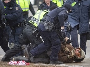 Arrests are made as police push back protesters that were congregating around Ambassador Plaza at Huron Line and Tecumseh, on Sunday, February 13, 2022.