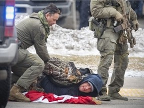 WINDSOR, ONTARIO:. FEBRUARY 13, 2022 - Arrests are made as police push back protesters that were congregating around Ambassador Plaza at Huron Line and Tecumseh, on Sunday, February 13, 2022.