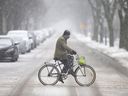 Ein Radfahrer stapft am Mittwoch, den 2. Februar 2022, durch den nassen Schnee auf der Cataraqui-Straße.