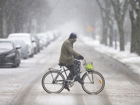 A cyclist trudges his way through the wet snow on Cataraqui Street, on Wednesday, Feb. 2, 2022.