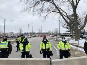 Police are seen behind a concrete barrier erected overnight near the Ambassador Bridge.