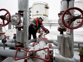 FILE PHOTO: A worker turns a valve at UdmurtNeft's Gremikhinskoye oil field east of Izhevsk near the Ural Mountains December 7, 2007.