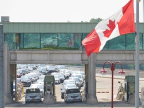 Travellers wait to cross into Canada at the Rainbow Bridge in Niagara Falls, Ont., in August as Canada reopened for non-essential travel to fully vaccinated Americans. But the need for a negative COVID test remains, to the consternation of border cities. (Photo by Geoff Robins / AFP)