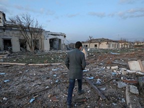 A man walks past damaged mansions following an overnight attack in Arbil, the capital of the northern Iraqi Kurdish autonomous region, on March 13, 2022.