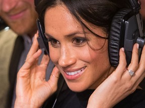 Britain's Prince Harry's fiancée US actress Meghan Markle listens to a broadcast through headphones during a visit to Reprezent 107.3FM community radio station in Brixton, south west London on January 9, 2018. (DOMINIC LIPINSKI/AFP via Getty Images)