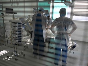 Health workers attend a patient infected with the Covid-19 at the intensive care unit for patients infected with the Covid-19 of the Timone hospital, in Marseille, southern France on January 5, 2022.