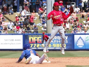 St. Louis Cardinals second baseman Kramer Robertson has to leap to catch a pickoff throw as New York Mets third baseman Jeff McNeil slides into the bag during the fifth inning of a spring training game at Clover Park.