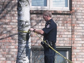 A LaSalle police officer fixes crime scene tape at the residence in the 1400 block of Sugarwood Crescent where Amanda Lyons' body was found on March 19, 2022.