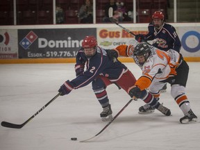 ESSEX, ONTARIO:. MARCH 13, 2022 - Essex' Andrew Thomas reaches for the puck against Petrolia's Keegan Watson in game 3 of the Junior C hockey playoffs between the Essex 73's and the Petrolia Flyers at the Essex Centre Sports Complex, on Sunday, March 13, 2022.