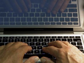 Hands at a laptop keyboard are shown in this file photo.