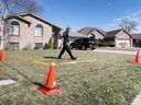 A LaSalle police officer walks behind crime scene tape at the home of Amanda and Blair Lyons on March 20, 2022.